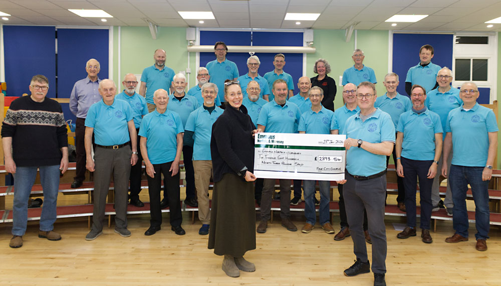 Treasurer Kim presents a whopping cheque to Cecile Roberts of Emmaus as the chorus smiles on